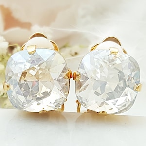 May include: A pair of gold tone clip-on earrings with large, clear, faceted, square-shaped crystals.