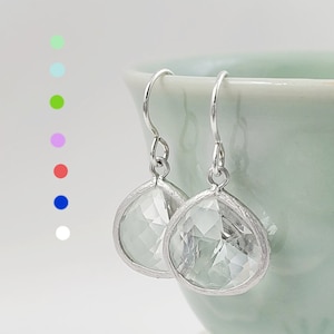 May include: A pair of silver dangle earrings with clear faceted crystal drops.