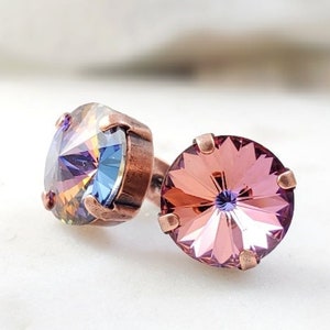 May include: A pair of copper stud earrings with iridescent blue and pink crystal stones.