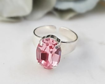 May include: A silver ring with a pink oval-shaped gemstone.