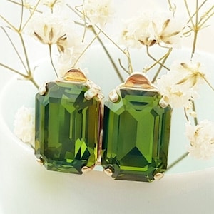 May include: A pair of gold tone clip-on earrings with emerald green rectangular shaped stones.