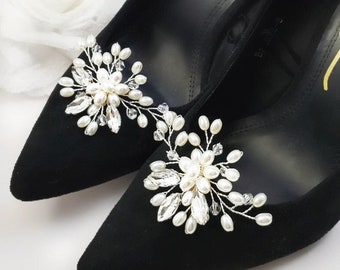 May include: A pair of black shoes with pearl and crystal embellishments. The shoes are decorated with two floral-shaped embellishments, each featuring a cluster of pearls and crystals. The text "Style 1" and "Choose Your Style!" is visible in the image.