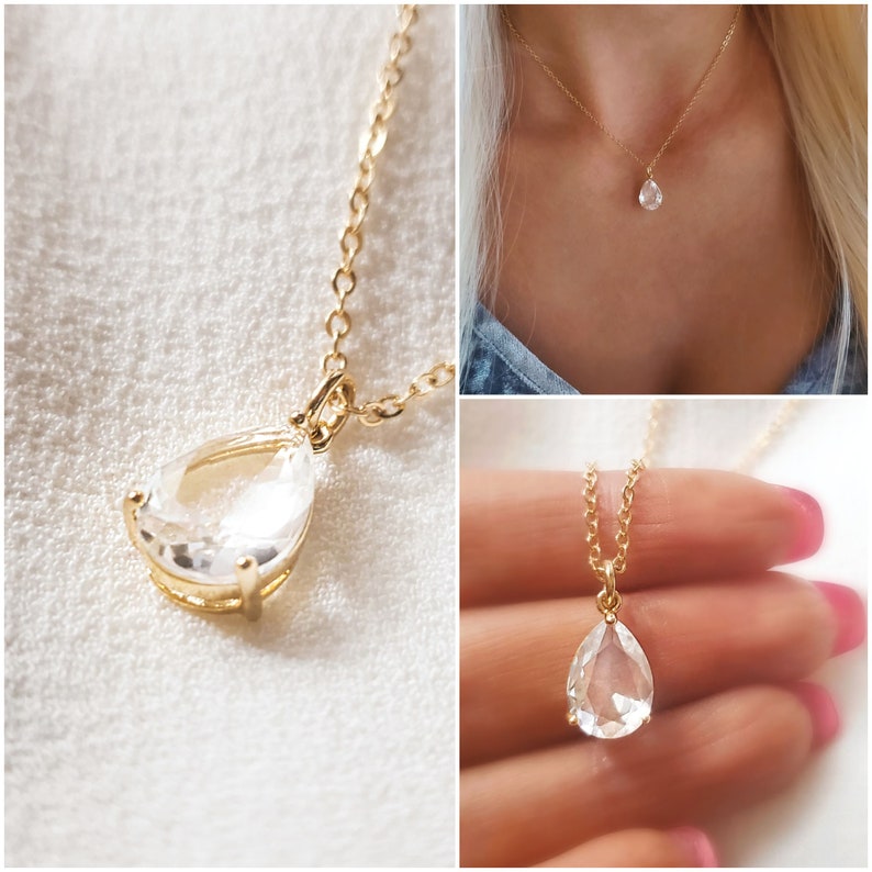 Puede incluir: Un collar de cadena dorada con un colgante de cristal transparente en forma de l&aacute;grima.