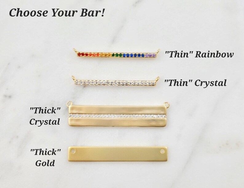 May include: Four gold bar necklaces with different styles. The top bar is thin and has rainbow colored crystals. The second bar is thin and has clear crystals. The third bar is thick and has clear crystals. The bottom bar is thick and is solid gold. The text "Choose Your Bar!" is at the top of the image. The text "Thin" Rainbow, "Thin" Crystal, "Thick" Crystal, and "Thick" Gold is below each bar.