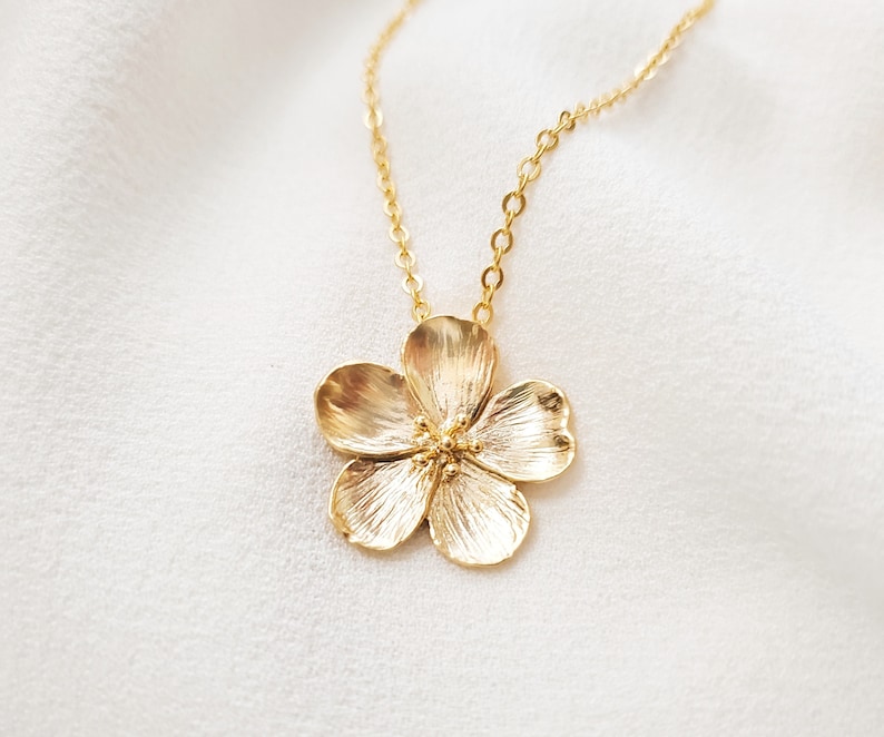 this beautiful matte gold cherry blossom flower pendant can be purchased as a pendant only or on a matching matte gold cable chain at 18 inches with a lobster clasp, a Gemsicles Etsy bestseller.