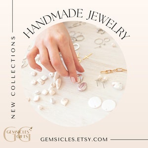 Peut inclure: Gros plan sur une surface blanche avec une vari&eacute;t&eacute; de bijoux faits main, dont des boucles d'oreilles en perles, une cha&icirc;ne en or et une croix en argent. Les bijoux sont dispos&eacute;s en cercle autour d'une main qui tend vers une boucle d'oreille en perle. Le texte "HANDMADE JEWELRY" est &eacute;crit en cercle au-dessus des bijoux. Le texte "NEW COLLECTIONS" est &eacute;crit verticalement sur le c&ocirc;t&eacute; gauche de l'image. Le texte "GEMSICLES.ETSY.COM" est &eacute;crit sous les bijoux.