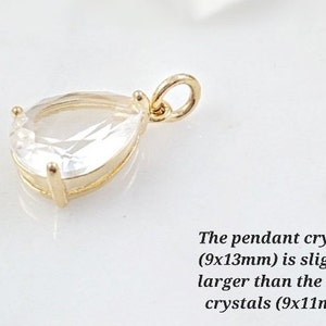 Puede incluir: Un colgante de oro con un cristal transparente en forma de l&aacute;grima. El colgante mide 9 mm por 13 mm.