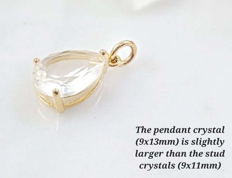 Puede incluir: Un colgante de oro con un cristal transparente en forma de l&aacute;grima. El colgante mide 9 mm por 13 mm.