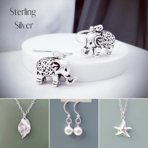 May include: Sterling silver jewelry set featuring three different designs: a pair of elephant earrings, a pair of pearl earrings, and a leaf pendant necklace.