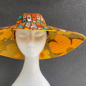 Sombrero de jardín reversible, ala ancha y de alambre, 2 en 1: tela reciclada con margaritas retro de los 60 y diseño geométrico de los 70 (marrón, naranja y amarillo). Talla mediana.