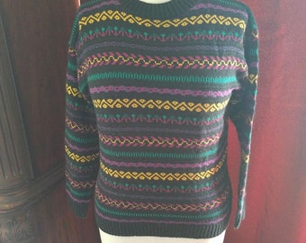 May include: A brown sweater with a colorful geometric pattern in shades of green, purple, yellow, and pink.