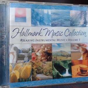 May include: A CD case with a blue background and a collage of nature scenes. The title is "Hallmark Music Collection: Relaxing Instrumental Music - Volume 1".