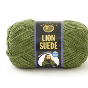 Könnte beinhalten: Eine Knäuel Lion Brand Suede Garn in einem tiefen Grünton. Das Etikett lautet "Lion Brand Yarn" und "Lion Suede" mit einem kostenlosen Muster im Inneren und Maschinenwaschanleitung.