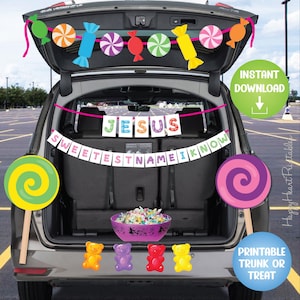 May include: A car trunk decorated for a trunk-or-treat event. The trunk is open and decorated with candy-themed cutouts and banners that read "JESUS SWEETEST NAME I KNOW". A bowl of candy and gummy bears are also visible.