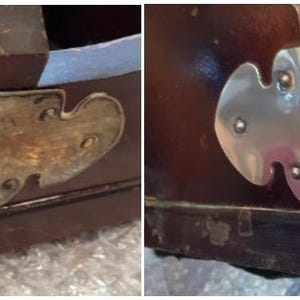 Op de afbeelding: Close-up van twee houten hoeken met decoratieve metalen accenten. De ene hoek heeft een messing accent, terwijl de andere een zilveren accent heeft. Beide accenten zijn in de vorm van een gestileerd blad.