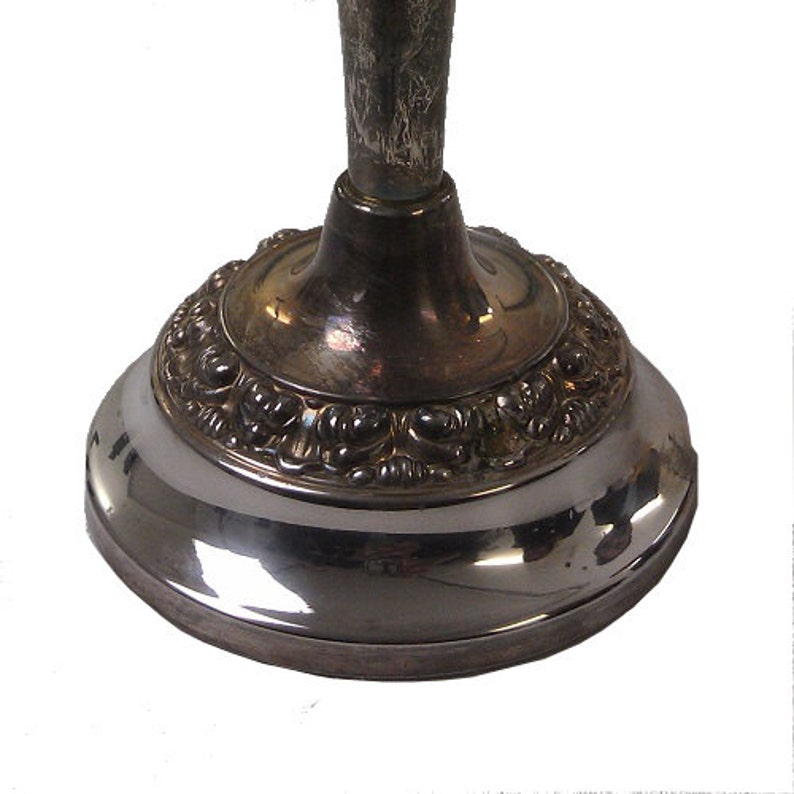 May include: Silver candlestick base with an ornate, detailed design. The base is round and has a smooth, polished finish.