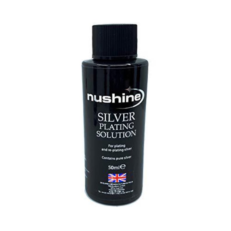 Op de afbeelding: Een zwarte fles met zilveren plating oplossing met het label "nushine SILVER PLATING SOLUTION". De fles is 50 ml en bevat puur zilver. Gemaakt in het Verenigd Koninkrijk.