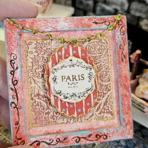 May include: A set of three ceramic mugs with a speckled, cream-colored glaze. Each mug features a different hand-painted floral design in shades of pink, blue, and green. The mugs have a simple, rounded shape and a comfortable handle.