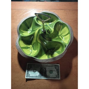 May include: A vintage green and gray ceramic serving dish with a handle. The dish has a unique, multi-sectioned design with a glossy green interior and a textured gray rim. The handle is made of gold-colored metal.