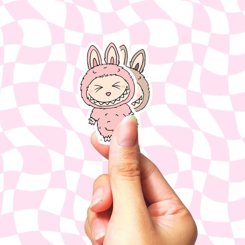 以下が含まれることがあります： ピンク色のステッカー。ウサギのコスチュームを着た漫画のキャラクターが、大きく歯を見せて笑っています。キャラクターはふわふわの体と大きな耳をしています。キャラクターの複製画像が少しずれています。背景はピンクと白のチェック柄です。