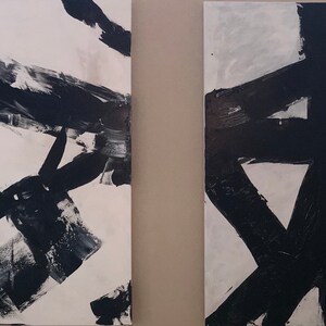 May include: Two abstract paintings with black brushstrokes on a white background. The paintings are side-by-side and are both rectangular in shape.