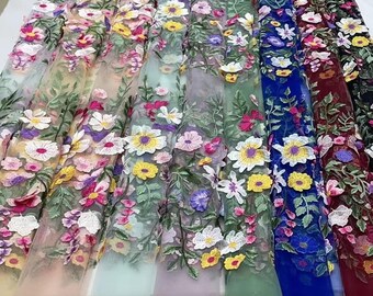 Pode incluir: Uma variedade de tecidos de tule bordados com flores em diferentes cores, incluindo bege, verde claro, lavanda, verde, azul e bordô.