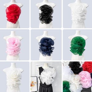 May include: A collection of decorative floral appliques in various colors, including red, black, white, pink, navy blue, and green. Each applique is designed to resemble a large, layered flower, with a ruffled texture. The appliques are displayed on dress forms.