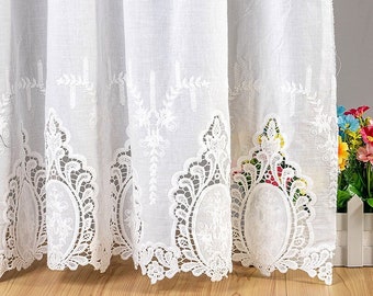 May include: White sheer curtains with a delicate lace trim and embroidered floral designs. The lace trim features a scalloped edge and intricate patterns.