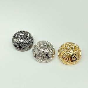 May include: Three decorative metal buttons with an openwork design. One is gunmetal, one is silver, and one is gold. The buttons are round and feature a swirling, ornate pattern.