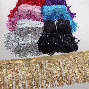 Könnte beinhalten: Sortiment an bunten, mit Pailletten besetzten Fransenborten in Silber, Gold, Schwarz, Rosa, Blau und Rot. Die Fransen bestehen aus kleinen, runden Pailletten.