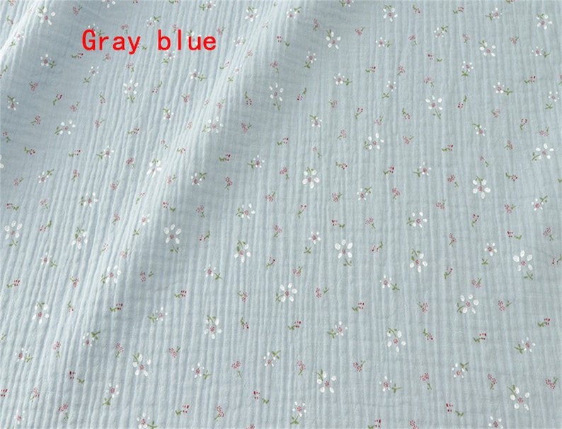 May include: A light blue fabric with a small white floral pattern. The fabric has a slightly textured surface.
