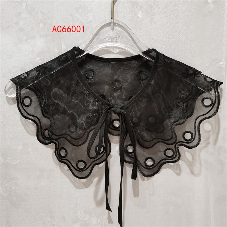 May include: Black sheer lace collar with a scalloped edge and a bow tie. The collar has a delicate floral pattern and small round cutouts. The text "AC66001" is visible in the top left corner of the image.