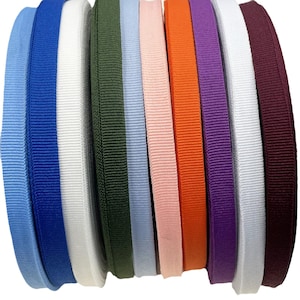 May include: A collection of colorful grosgrain ribbons in various shades, including blue, white, green, pink, orange, purple, and burgundy. The ribbons are neatly arranged, showcasing their textured surface and vibrant hues. Ideal for crafting and decorative projects.