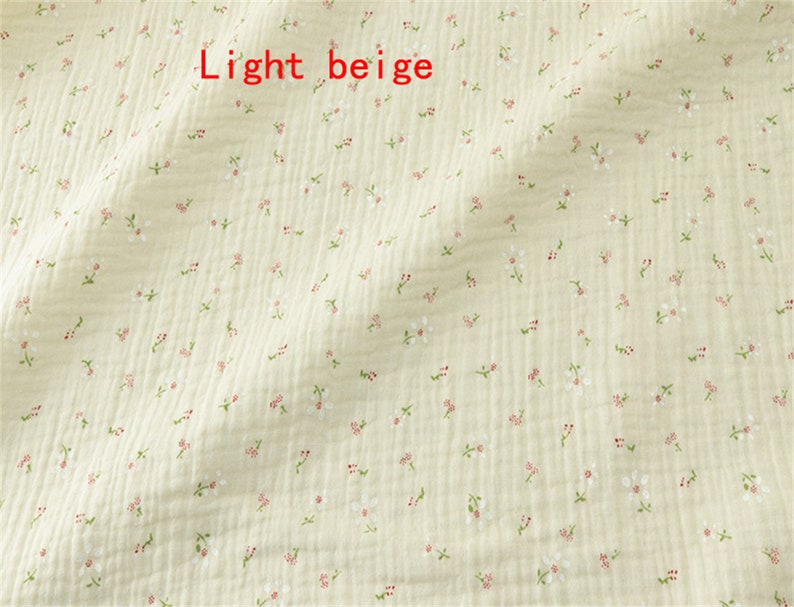 May include: Light beige fabric with a small white floral pattern.