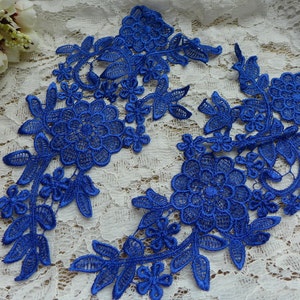 May include: Royal blue floral lace appliques. The appliques feature detailed floral and leaf designs. The lace is arranged on a white lace background. The appliques are suitable for various craft projects, including embellishing garments or accessories.