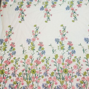 May include: White floral embroidered fabric with pink, green, and blue flowers. The fabric has a sheer, mesh-like texture.