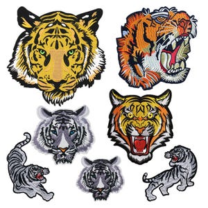 May include: A collection of embroidered tiger patches in various designs. The patches feature detailed tiger faces with open mouths, and full body poses. Colors include yellow, orange, black, white, and gray.