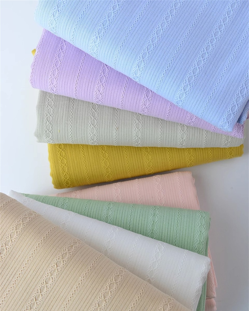May include: A stack of six different colored ribbed fabrics with a delicate lace pattern. The colors are light blue, lavender, beige, yellow, pink, and green.