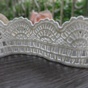 May include: White crochet lace trim with a scalloped edge and delicate floral pattern.
