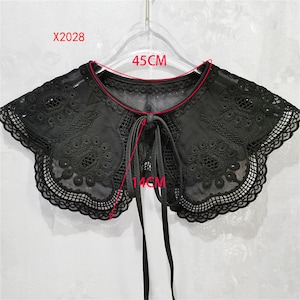 May include: Black lace collar with a bow tie, measuring 45 cm wide and 14 cm long. X2028.