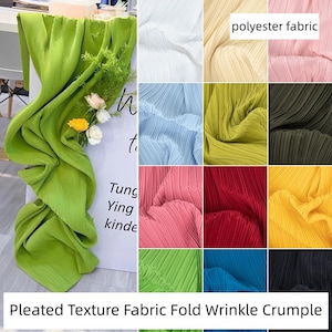 Op de afbeelding: Een display van geplooide polyester stof in verschillende kleuren, waaronder groen, wit, blauw, roze, rood en geel. De afbeelding bevat de tekst "polyester fabric" en "Pleated Texture Fabric Fold Wrinkle Crumple."
