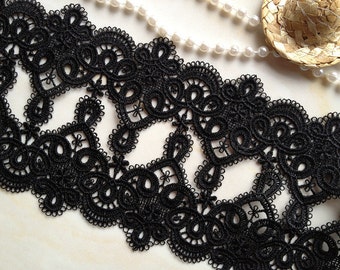 May include: Black lace trim with a delicate floral pattern. The trim is made of a fine, lightweight material and has a scalloped edge.