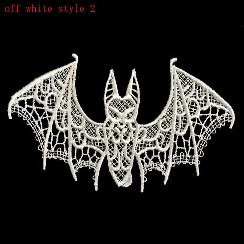 May include: Off-white lace bat with an elaborate openwork pattern. The bat features extended wings and a detailed body, suitable for Halloween or gothic crafts. The text "off white style 2" is in the upper left corner.