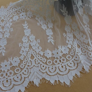 Puede incluir: Borde de encaje blanco con un borde festoneado y un patr&oacute;n floral. El encaje es delicado y tiene un tacto suave y rom&aacute;ntico.