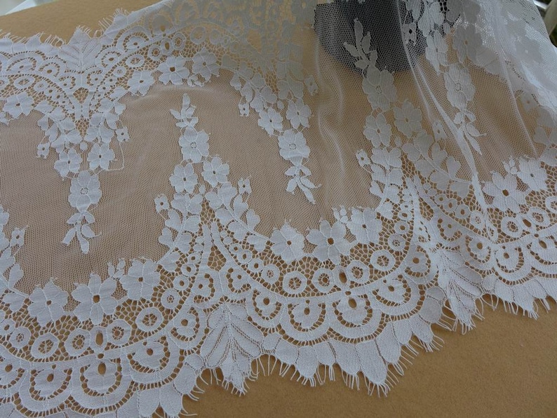Puede incluir: Borde de encaje blanco con un borde festoneado y un patr&oacute;n floral. El encaje es delicado y tiene un tacto suave y rom&aacute;ntico.