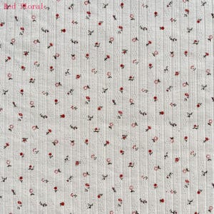 May include: White ribbed fabric with a repeating pattern of small red and pink flowers and dark green stems. The text "Red Floral" is in the upper left corner. The fabric has a textured, vertical striped design.