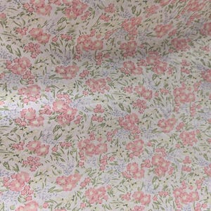 Puede incluir: Una tela con un estampado floral repetido. El dise&ntilde;o presenta grupos de flores rosas, peque&ntilde;as flores azules y hojas verdes sobre un fondo blanco. El efecto general es delicado y femenino.