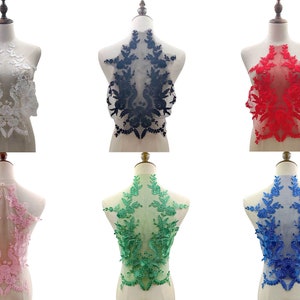 Op de afbeelding: Zes kant-applicaties in verschillende kleuren, waaronder wit, zwart, rood, roze, groen en blauw. Elke applicatie heeft een bloemmotief met ingewikkelde details.