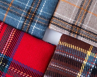 May include: Close-up of four folded plaid fabrics in shades of red, blue, brown, and grey. Each fabric features a distinct plaid pattern with intersecting lines in various colours, creating a textured appearance. The fabrics are arranged to form a square.