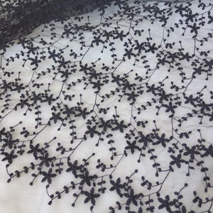 K&ouml;nnte beinhalten: Schwarzer Blumenspitze Stoff mit einem zarten Muster aus kleinen Blumen und Ranken. Die Spitze ist durchsichtig und leicht, was sie ideal f&uuml;r eine Vielzahl von Bastelprojekten macht.